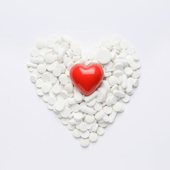 Heart made of pills on white background