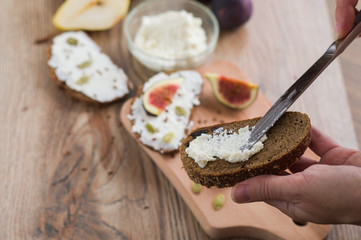 woman makes sandwiches with curd cheese and figs