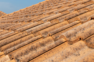 Close up of brown clay roof tiles. Red old dirty roof. Old roof tiles. Construction equipment build a house.