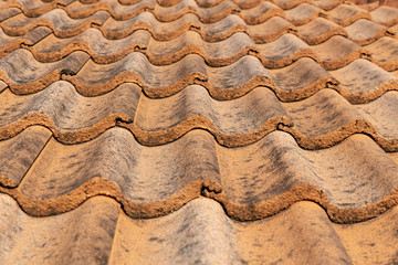 Close up of brown clay roof tiles. Red old dirty roof. Old roof tiles. Construction equipment build a house.