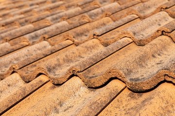 Close up of brown clay roof tiles. Red old dirty roof. Old roof tiles. Construction equipment build a house.