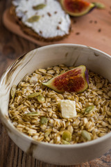 oatmeal with butter seeds and figs on a wooden table