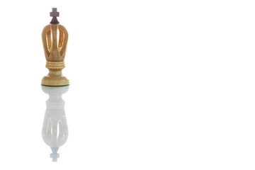 A view of king white chess piece. Wooden chess pieces against white color background