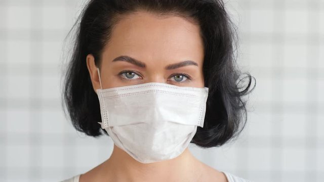 Confident brunette woman wearing medical mask.