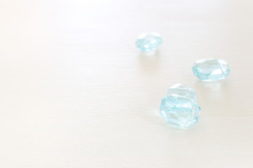 Delicate blu gemstones beads on white wooden background