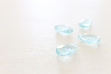 Delicate blue gemstones beads on white wooden background