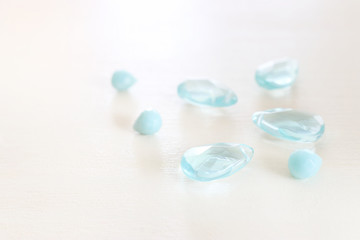 Delicate blue and chalcedony gemstones beads on white wooden background