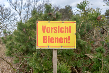 Warning sign in nature with German text: Beware of bees