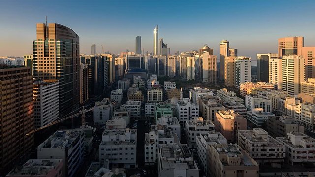Sunrise Timelapse with moving light in shadows over the buildings in Abu Dhabi City, United Arab Emirates