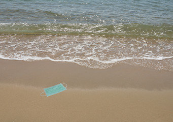 hygienic mask for protection nose and mouth trash on beach in sunny say