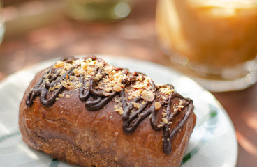 Cocoa bread topped with almonds on a wooden table