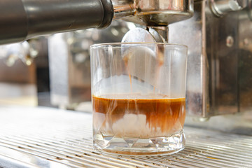 The barista is making cappuccino coffee on an espresso machine.