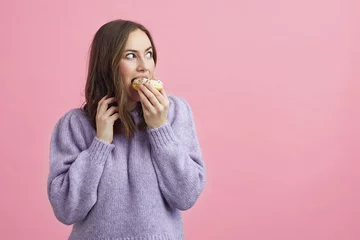Fotobehang Pretty girl is eating a cake, and looking to se if anyone i seing her  © Martin Villadsen