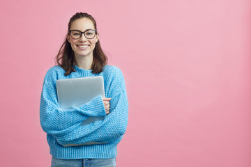 Cute looking student holding her laptop beside copy space  - obrazy, fototapety, plakaty