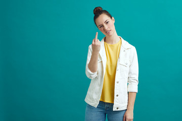 Girl is giving the fuck finger to the camera while standing on a colorful background