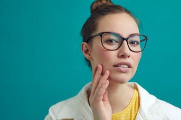 Beautiful girl looking into the camera / mirror to se her new look with glasses