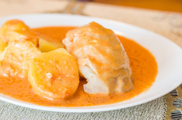 Polish traditional cabbage roll known as golabki. Golabki with tomato sauce and potatoes.