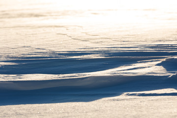 Snow plains formed by the wind backlit by the sun