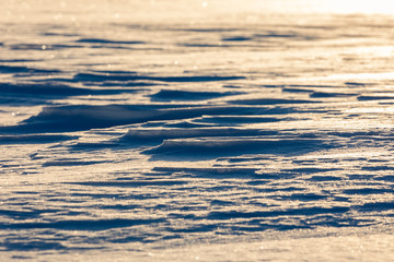 Snow plains formed by the wind backlit by the sun