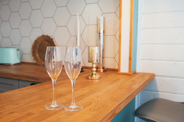 Two beautiful champagne glasses on the wooden countertop of the cozy Scandinavian-style kitchen.