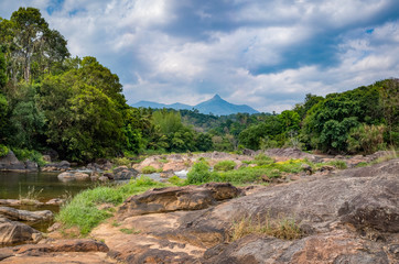 Fototapeta na wymiar Rocky river and mountain peak, Kerala, India