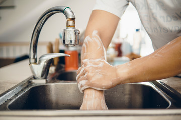 Mature man washing hands in the kitchen