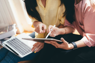 Close up women using online mobile gadget together