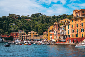 Fototapeta na wymiar Stunning panoramic view of Portofino, one of the world’s most beautiful seaside towns on the Italian Riviera. Mediterranean landscape of yacht-filled harbor and colorful buildings on a sunny day.