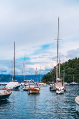Fototapeta na wymiar Stunning panoramic view of Portofino, one of the world’s most beautiful seaside towns on the Italian Riviera. Mediterranean landscape of yacht-filled harbour and mountains in the background.