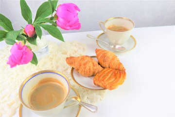 breakfast with two cups of coffee and croissants, bouquet