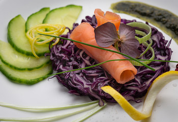Talerz świeżego wędzonego łososia na świeżych warzywach na białym talerzu, z jaskrawymi kolorami i białym tłem - 333649583