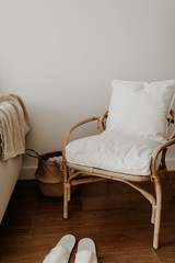 Rattan chair and basket, pillows and blanket in an empty room