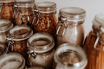 Glass jars full with dried uncooked food ingredients