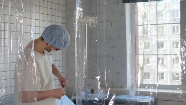 Young man doctor puts the dropper to himself.
