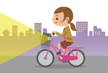 ライトを点灯し自転車を運転する女子生徒(背景あり)