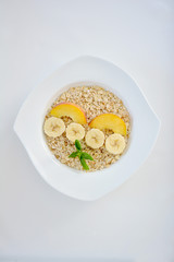 Fresh oatmeal porridge with banana, peach and honey for healthy breakfast