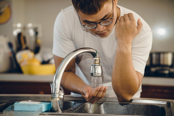 Cropped shot of an unrecognizable man washing his hands  at home to prevent spreading of the coronavirus ( Covid-19)