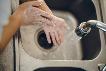 Cropped shot of an unrecognizable man washing his hands  at home to prevent spreading of the coronavirus ( Covid-19)