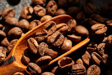 Wooden spoon with roasted coffee beans. Top view. Macro