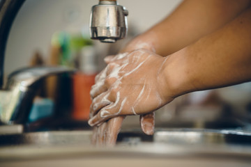 Cropped shot of an unrecognizable man washing his hands  at home to prevent spreading of the coronavirus ( Covid-19)