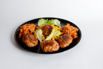 Fried chicken cutlet with potato slices served with tomato cherry and corn salad. Traditional belorussian food - roasted minced meat and potato