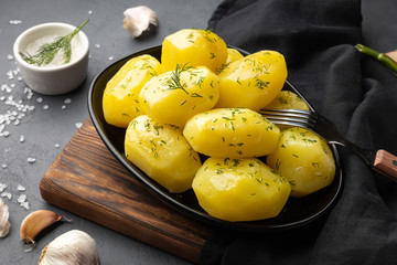 Boiled potatoes with dill and oil on plate