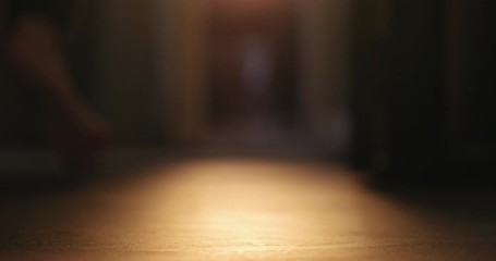 Slow motion low angle man walks with bare feet to close curtains to soften sunset light - Powered by Adobe