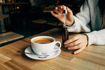 Adding CBD oil in a coffee cup