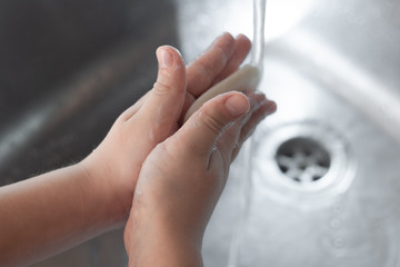 Child washing hands with soap