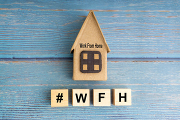 Concept image a wooden block and word - #WFH ( WORK FROM HOME ) on wooden background