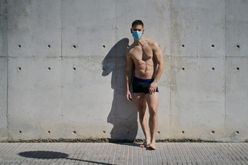 Portrait of a gorgeous guy wearing a mask to avoid infection. Coronavirus concept