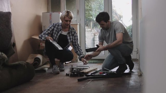 Couple putting together flatpack shelving