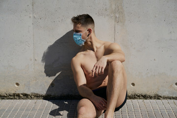 Portrait of a gorgeous guy wearing a mask to avoid infection. Coronavirus concept