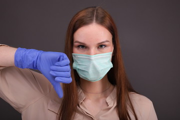 Woman in protective mask and gloves shows dislike
